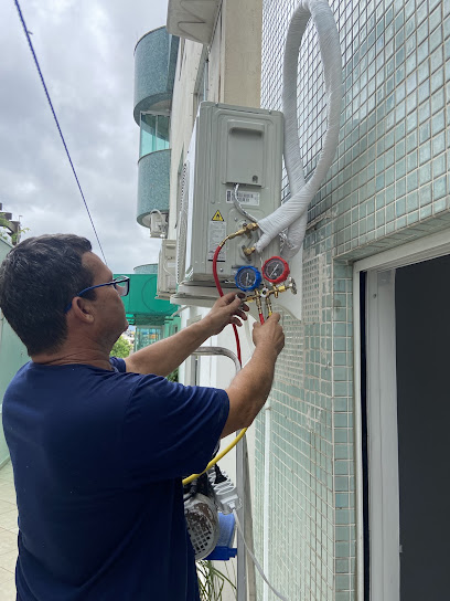 Técnico da Moura Eletroclimatização conectando manifold em condensadora de ar-condicionado split